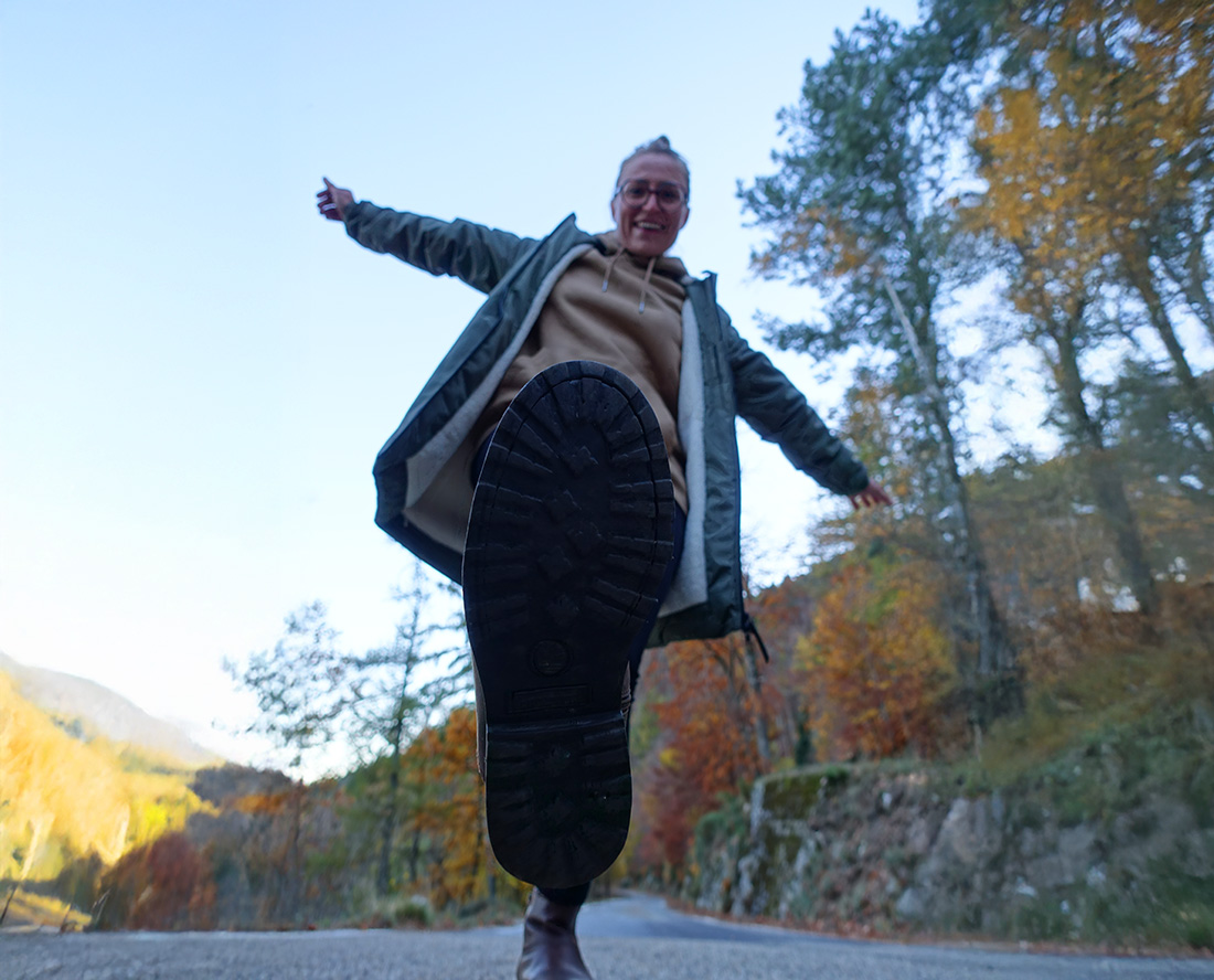 Femme sautant en pleine nature en tenue outdoor, liberté et mouvement