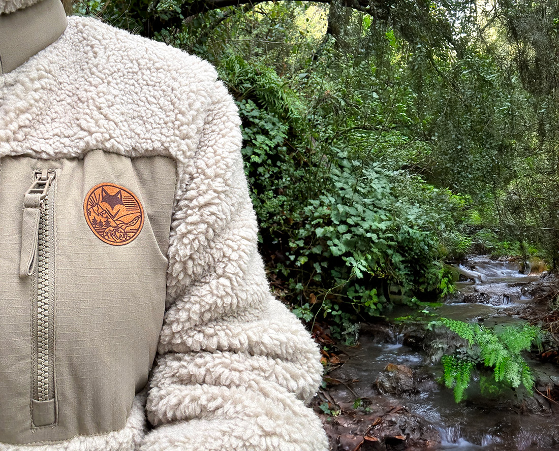 Détail poitrine d’une veste sherpa avec patch logo, marque outdoor responsable