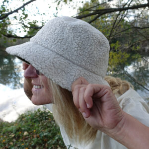 Femme portant un bob sherpa écoresponsable, promenade en forêt.