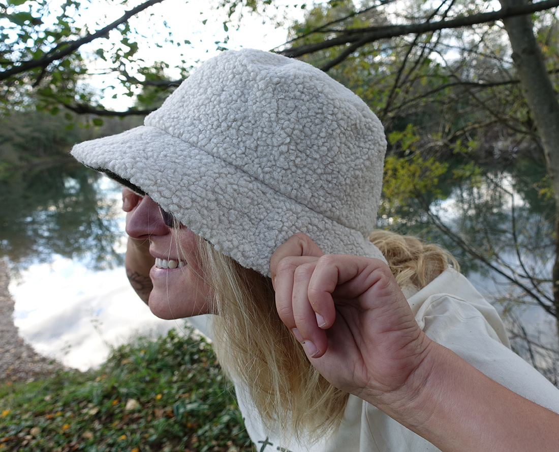 Femme portant un bob sherpa écoresponsable, promenade en forêt.