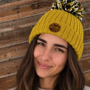 femme portant le bonnet extra chaud doublé peluche devant planche devant un chalet de montagne