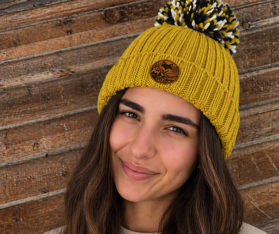 femme portant le bonnet extra chaud doublé peluche devant planche devant un chalet de montagne