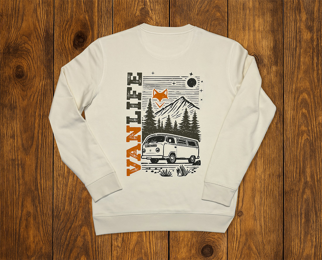 Sweat écru vanlife présenté à plat sur fond bois, mode outdoor durable