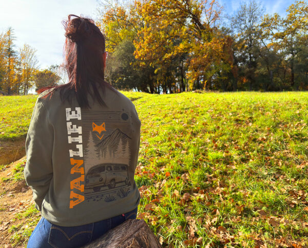 Femme assise dans un champ en sweat vanlife, ambiance automne et liberté