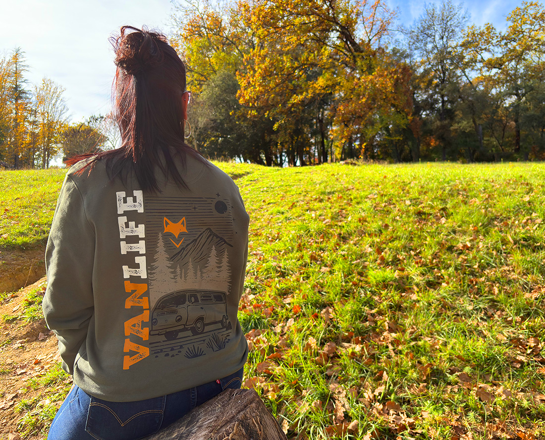 Femme assise dans un champ en sweat vanlife, ambiance automne et liberté