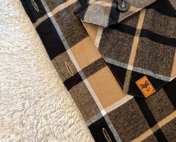 Gros plan sur poche de notre chemise à carreaux avec patch logo, doublure sherpa