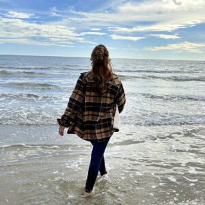 Femme marchant sur la plage en chemise outdoor, liberté et horizon