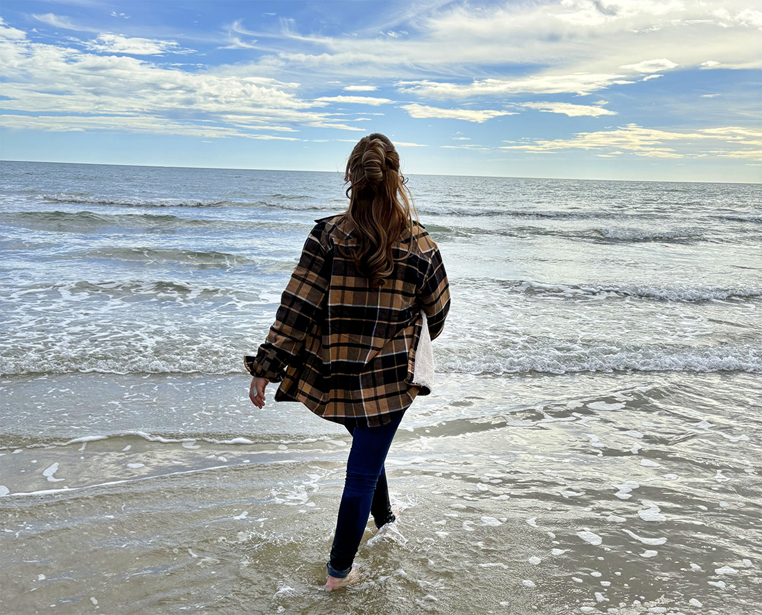 Femme marchant sur la plage en chemise outdoor, liberté et horizon