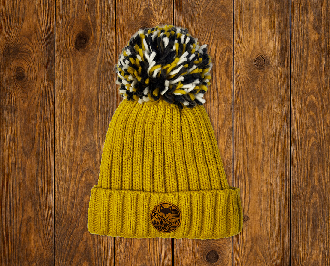 Bonnet doublure peluche avec pompon sur planche en bois prise en studio