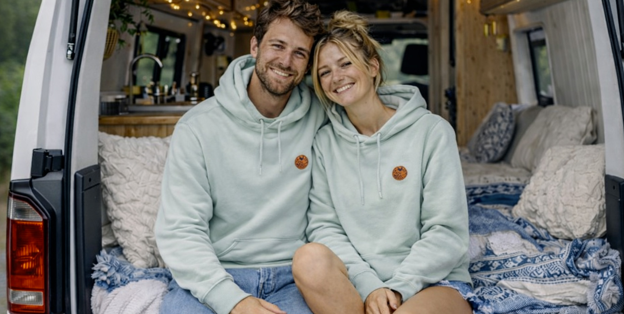 Couple mixte portant le sweat polaire 100% recyclé en bouteille plastique à l'arrière d'un van aménager