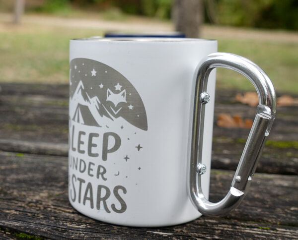 gros plan sur notre mug vanlife sur plan en bois sur table en extérieur