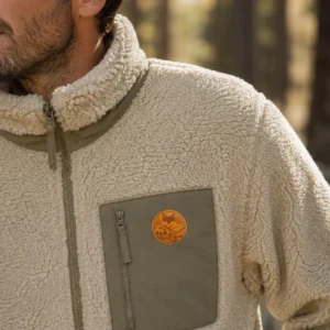 Gros plan sur une veste sherpa beige et son écusson, style van life outdoor