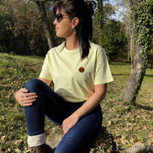 Femme assise en forêt portant un t-shirt jaune clair, esprit slow life