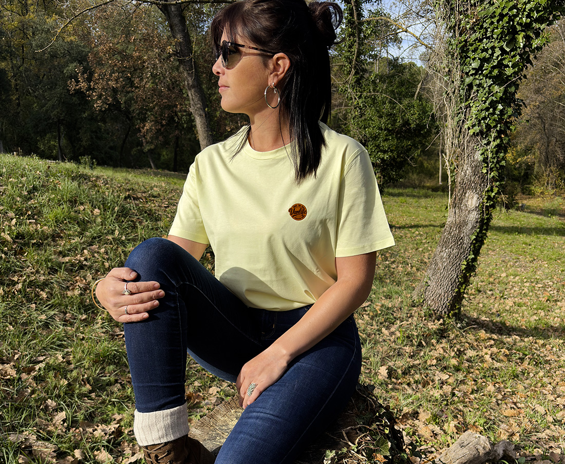 Femme assise en forêt portant un t-shirt jaune clair, esprit slow life