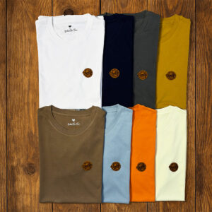 Sélection de t-shirts pliés présentés sur fond bois, collection vanlife durable