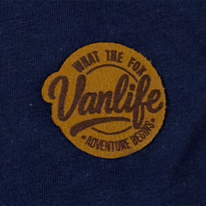 Gros plan sur patch logo Vanlife cousu sur t-shirt bleu marine