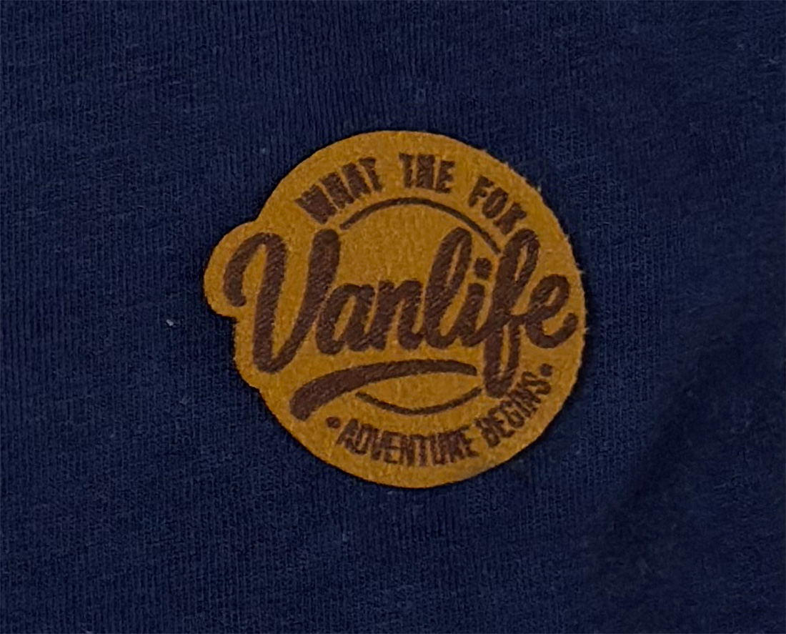 Gros plan sur patch logo Vanlife cousu sur t-shirt bleu marine