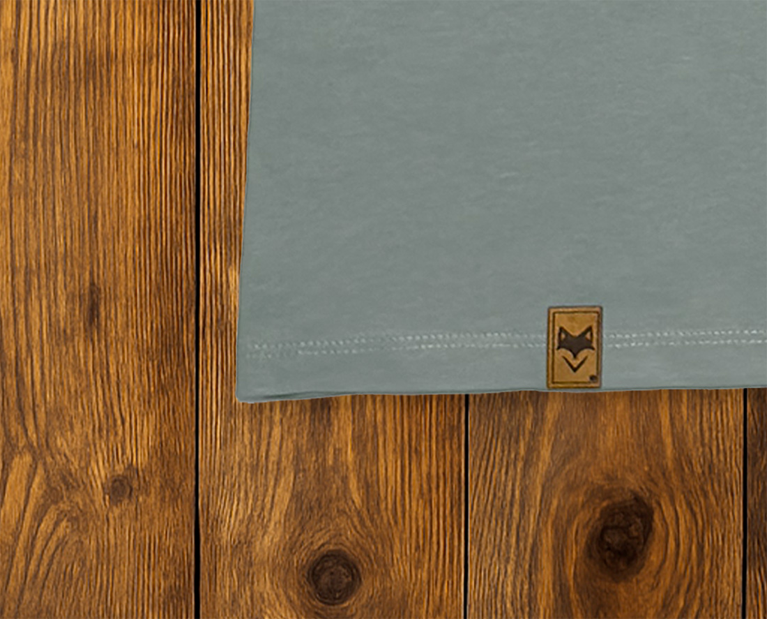 Gros plan sur ourlet d’un t-shirt bleu gris avec étiquette, textile responsable