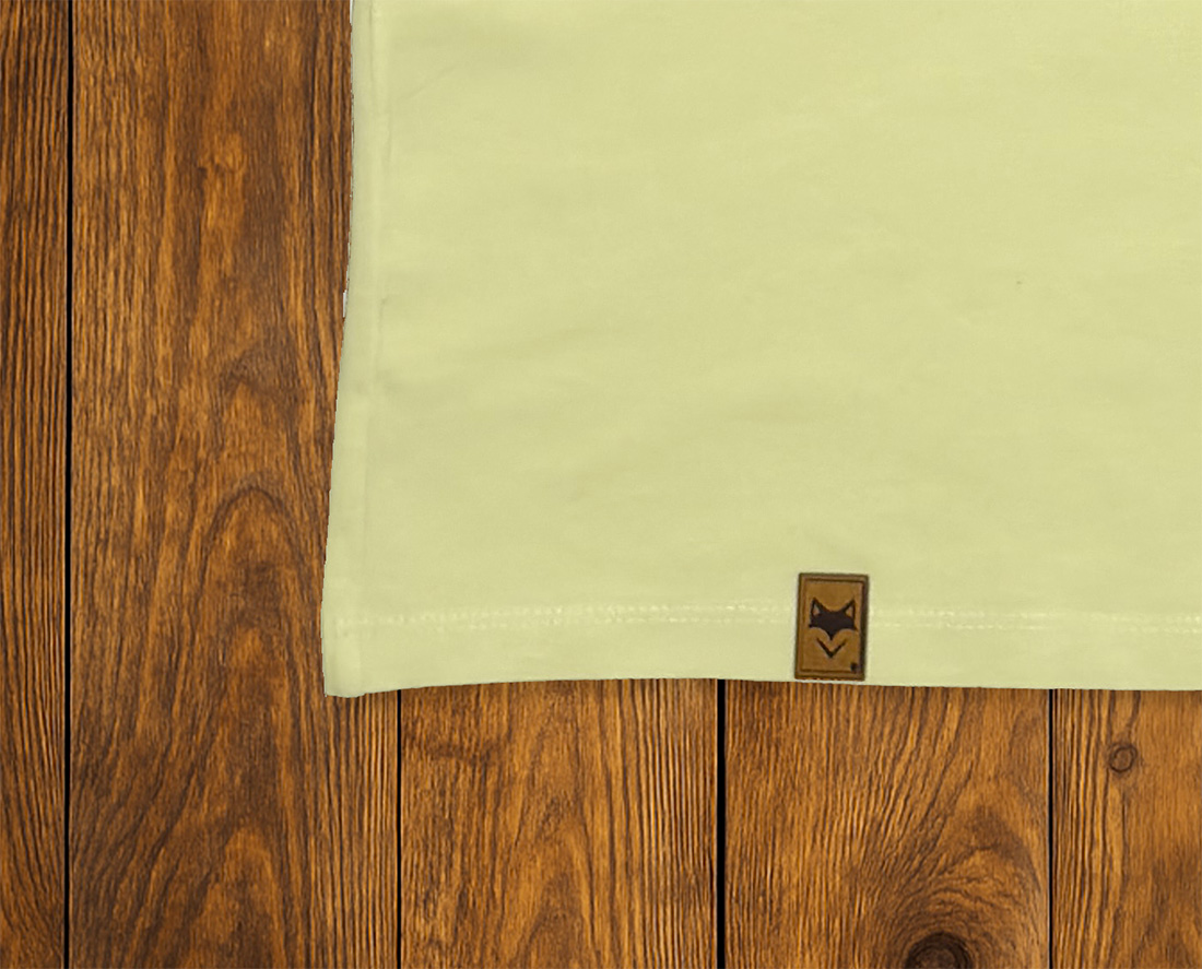 Gros plan sur ourlet et étiquette d’un t-shirt jaune clair, finition responsable
