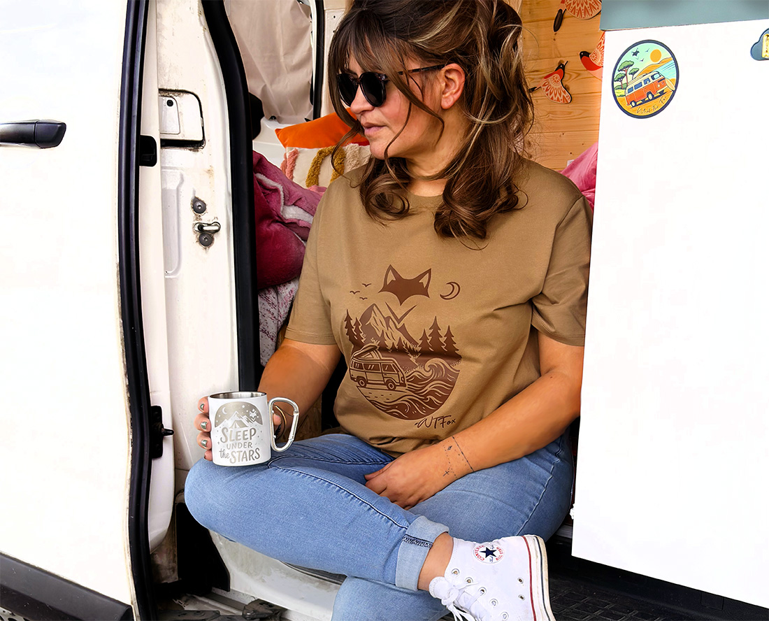 Femme assise dans un van en t-shirt illustré, lifestyle nomade