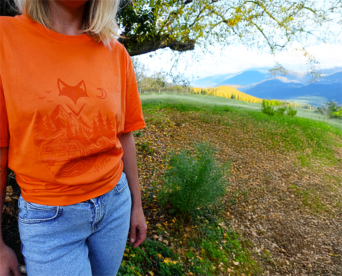 Femme en t-shirt orange au bord d’un lac, connexion à la nature