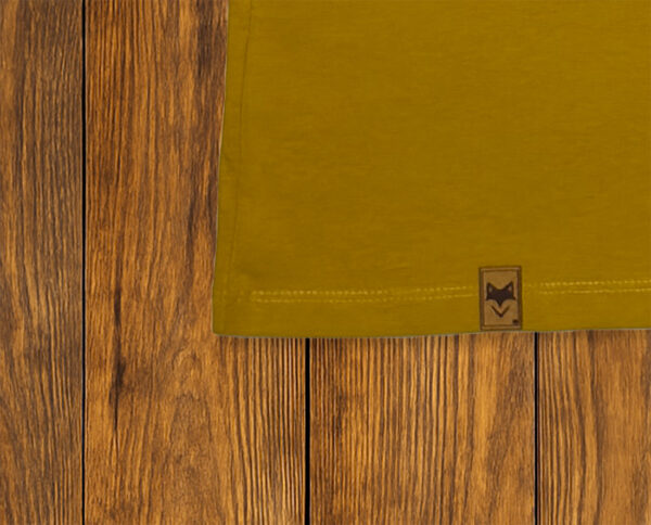 Gros plan sur ourlet et étiquette d’un t-shirt jaune, finition responsable