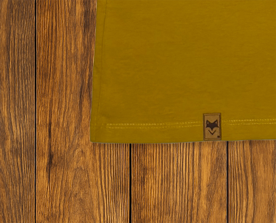 Gros plan sur ourlet et étiquette d’un t-shirt jaune, finition responsable