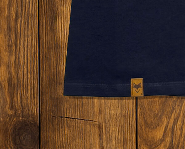 Gros plan sur ourlet d’un t-shirt bleu marine avec étiquette, finition responsable