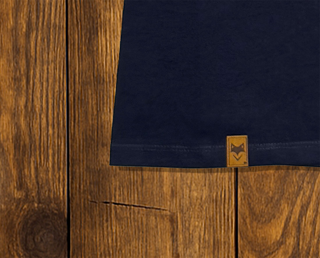 Gros plan sur ourlet d’un t-shirt bleu marine avec étiquette, finition responsable