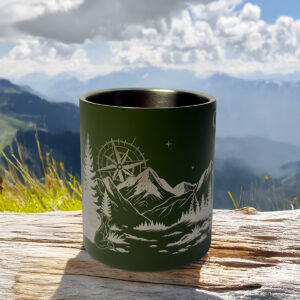 Tasse vanlife posée sur un bout de bois devant un paysage naturel