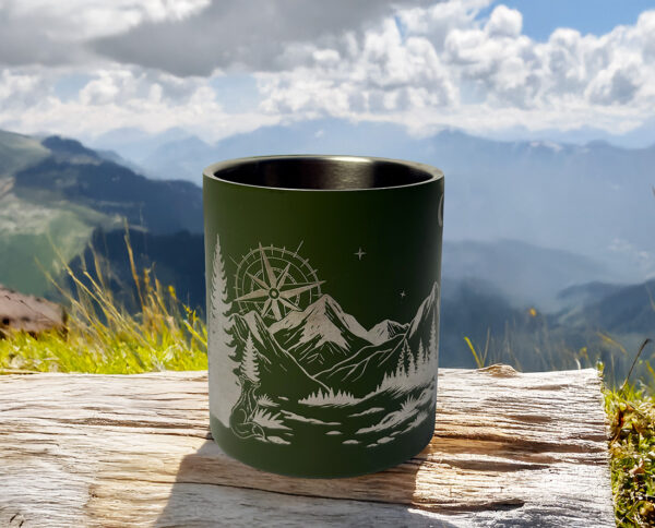 Tasse vanlife posée sur un bout de bois devant un paysage naturel