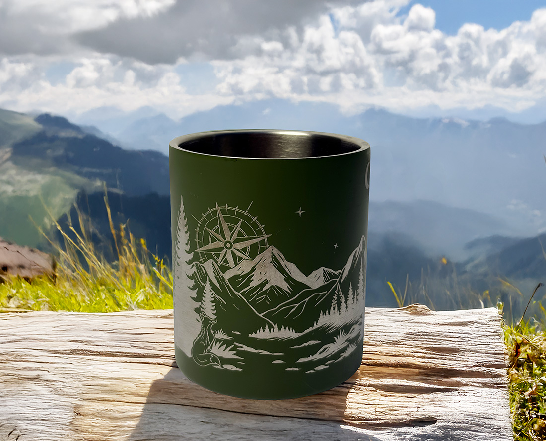 Tasse vanlife posée sur un bout de bois devant un paysage naturel