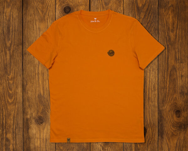 T-shirt orange présenté à plat sur fond bois, vêtement lifestyle durable