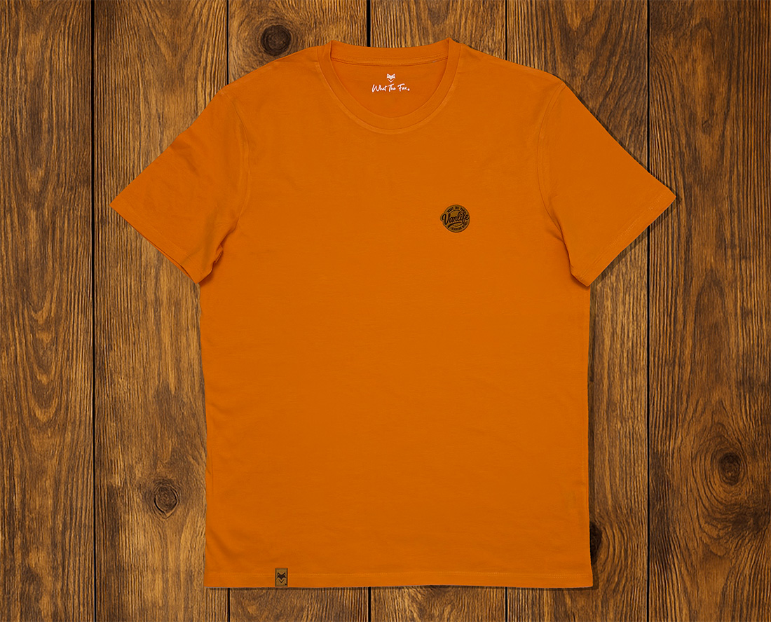 T-shirt orange présenté à plat sur fond bois, vêtement lifestyle durable