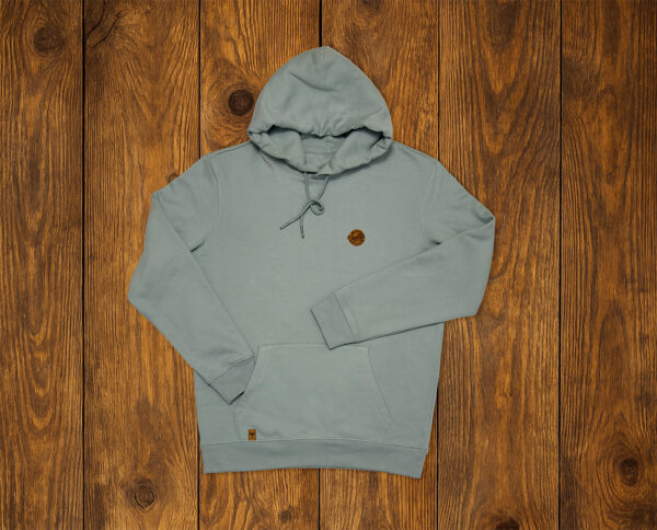 Sweat à capuche rivière alpine présenté à plat sur fond bois, hoodie lifestyle durable