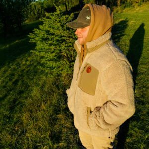 Homme portant une veste sherpa beige en pleine nature, esprit aventure et vanlife