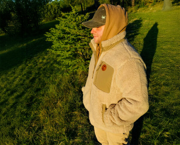 Homme portant une veste sherpa beige en pleine nature, esprit aventure et vanlife