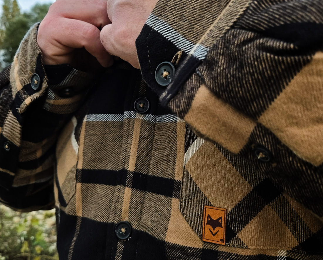 Détail d’une veste à carreaux avec boutons et écusson suédine, vêtement chaud écoresponsable