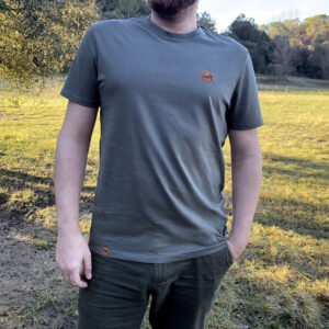 Homme portant un t-shirt de couleur verdure nomade écoresponsable avec logo minimaliste sur la poitrine.