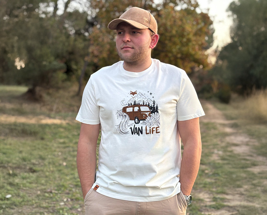 Homme portant un t-shirt vanlife blanc près d’un lac, lifestyle outdoor