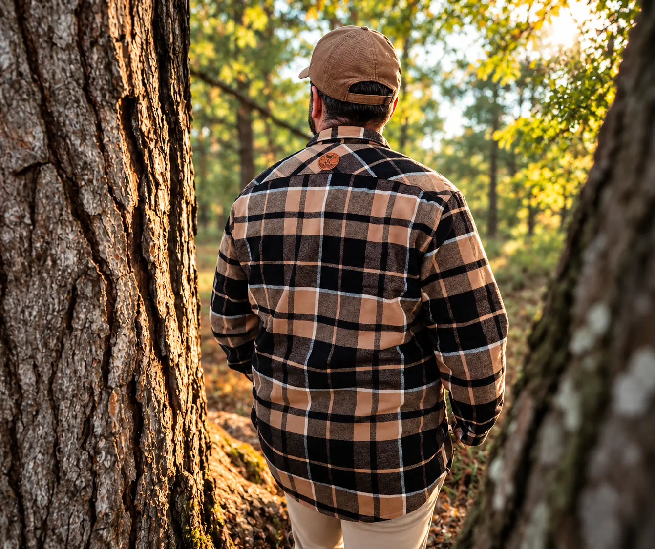 Homme portant une chemise sherpa à carreaux beige et noire dans une forêt