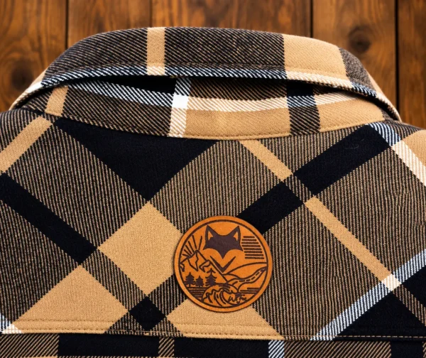 Détail du dos d'une chemise sherpa homme à carreaux beige et noire avec logo What The Fox