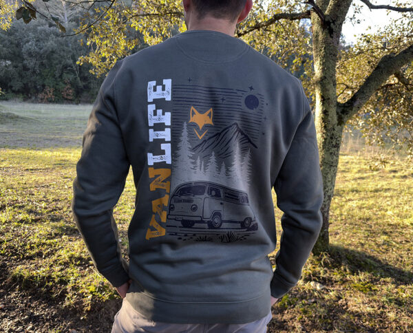 Homme de dos portant un sweat verdure nomade avec graphisme montagne et van.