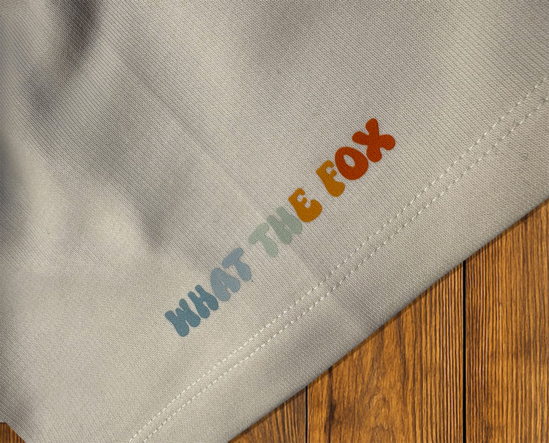 Détail “What the Fox” sur t-shirt clair, identité de marque outdoor