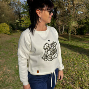 Femme portant un sweat vanlife blanc en extérieur, style outdoor casual et responsable