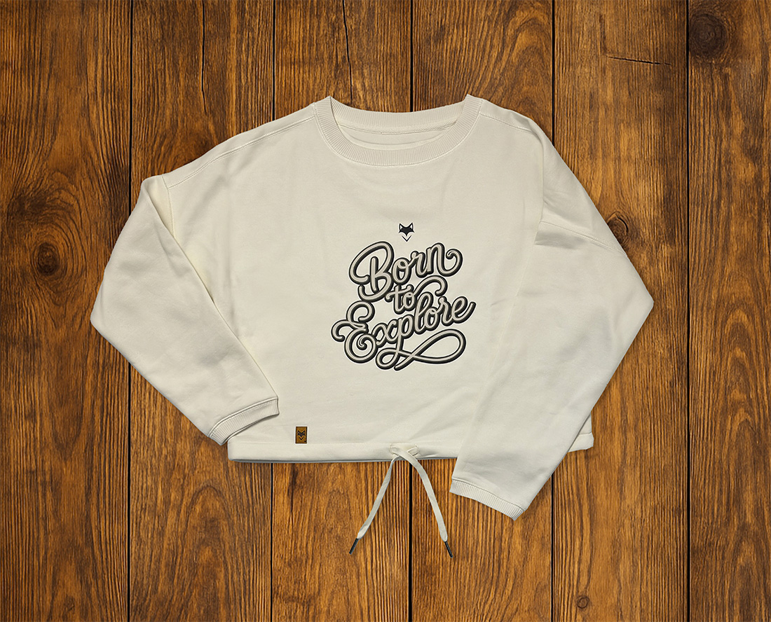 Sweat écru à manches longues avec illustration vanlife, posé à plat sur fond bois