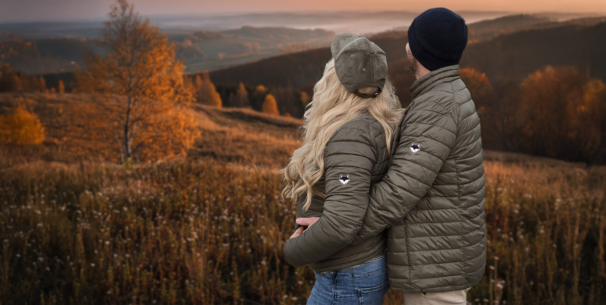 photo d'un couple mixte portant la doudoune verdure nomade enlacé devant paysage montagne