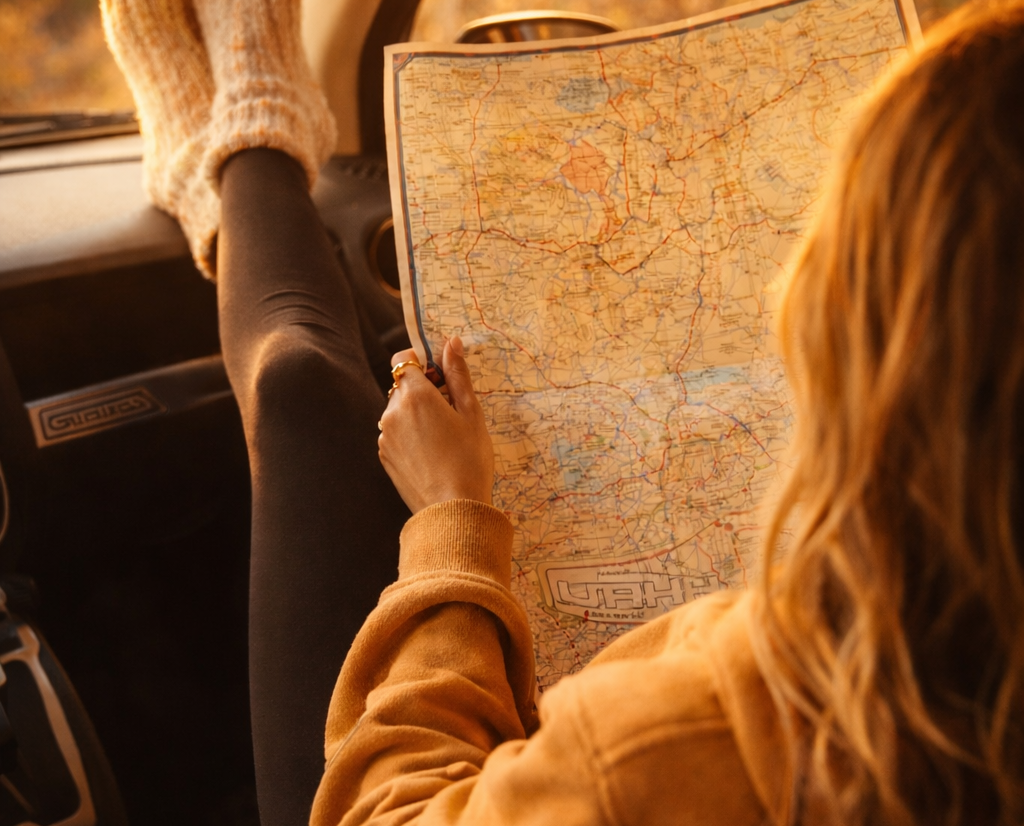 femme regardant une carte routière assise dans un van aménager en plein road trip