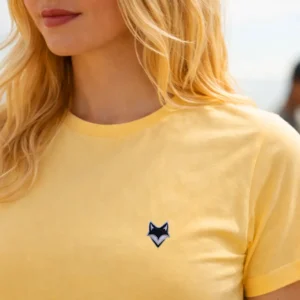 Zomm sur femme portant un t-shirt vanlife jaune en bord de mer – esprit été vanlife en bord de mer
