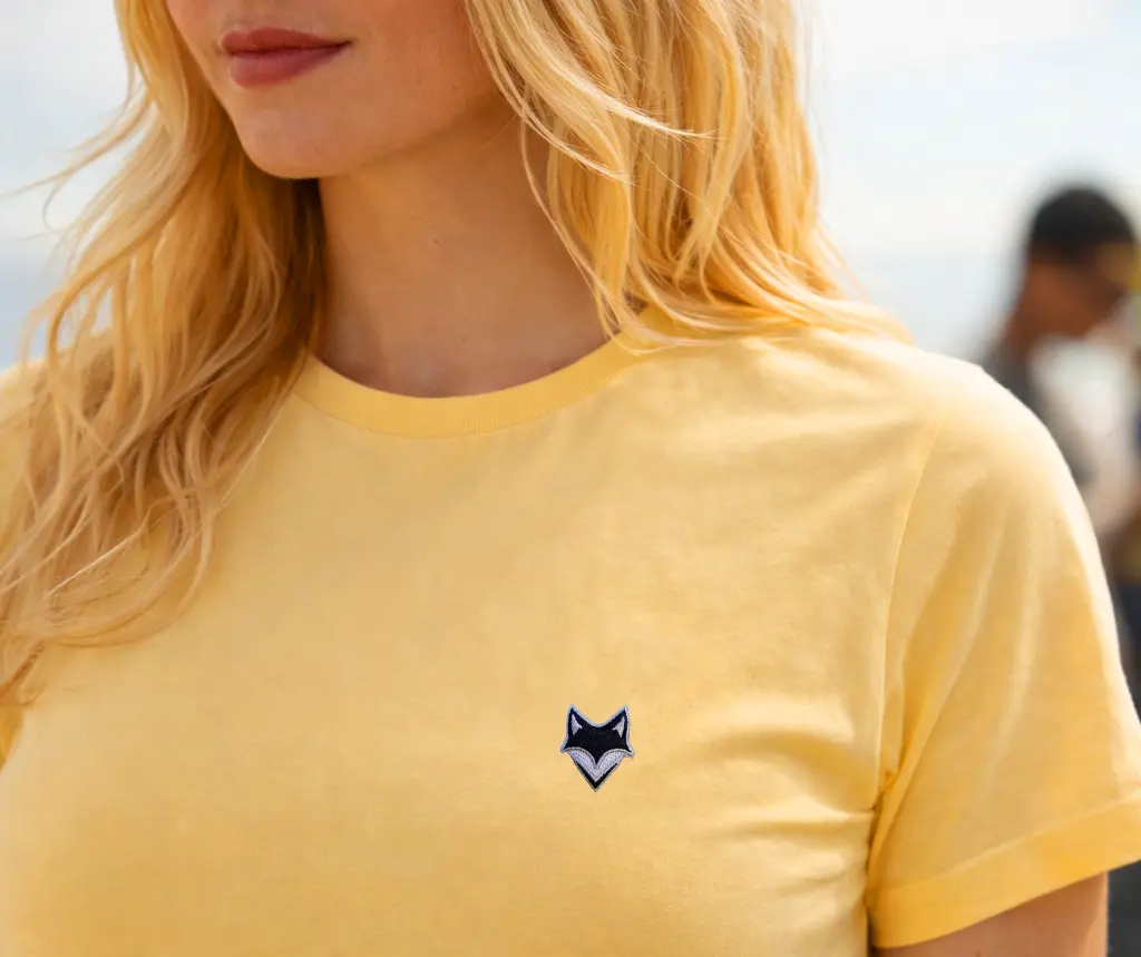 Zomm sur femme portant un t-shirt vanlife jaune en bord de mer – esprit été vanlife en bord de mer